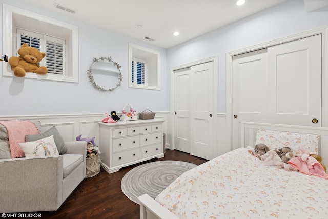 bedroom featuring dark hardwood / wood-style flooring and multiple closets