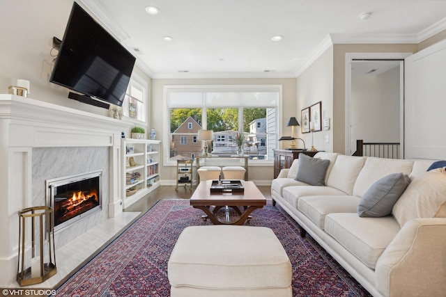 living room featuring a high end fireplace and ornamental molding