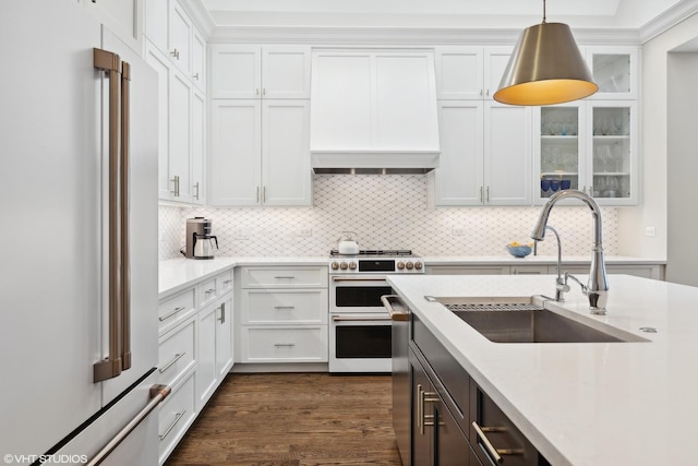 kitchen featuring sink, hanging light fixtures, premium appliances, tasteful backsplash, and white cabinets