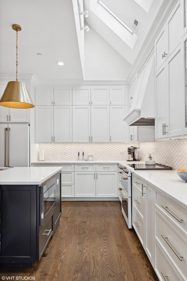 kitchen featuring white cabinets, premium appliances, backsplash, and custom exhaust hood