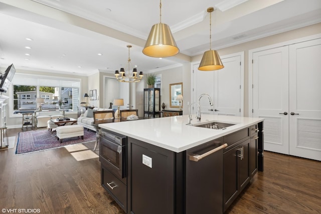 kitchen featuring dishwasher, an island with sink, hanging light fixtures, and sink