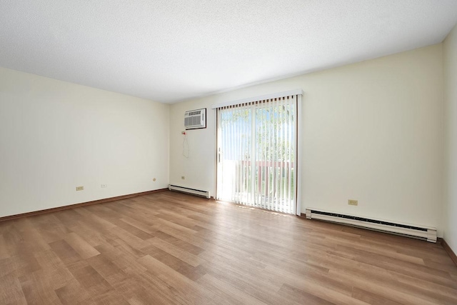 empty room with a wall mounted air conditioner, light hardwood / wood-style floors, and baseboard heating