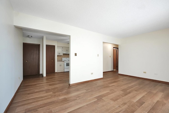 spare room featuring light hardwood / wood-style floors and a textured ceiling