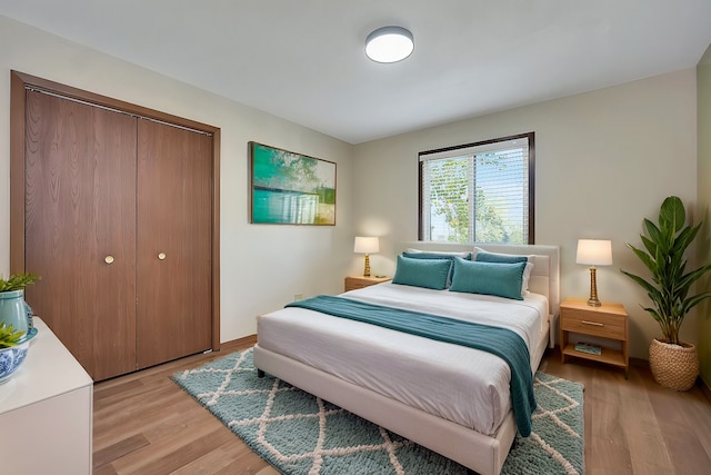 bedroom with light hardwood / wood-style floors and a closet