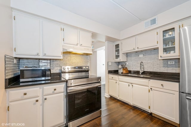 kitchen with stainless steel appliances, white cabinetry, backsplash, and sink