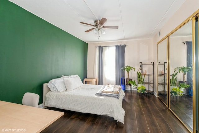 bedroom featuring dark hardwood / wood-style flooring, ceiling fan, and a closet