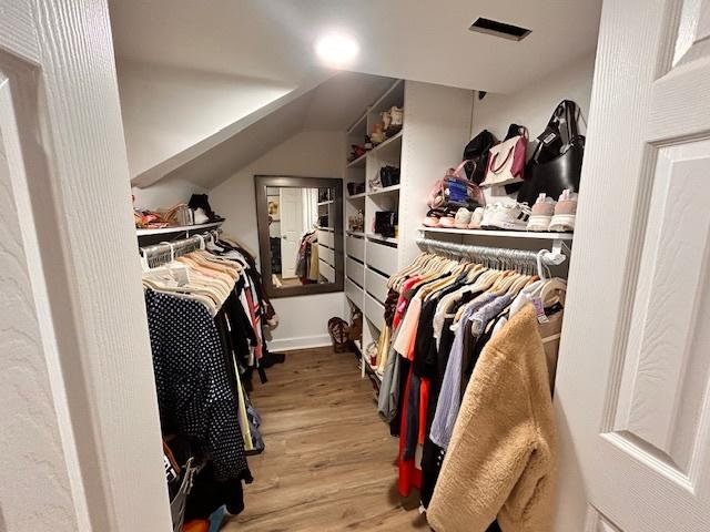 walk in closet with hardwood / wood-style flooring