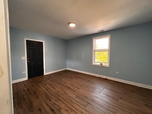 empty room with dark hardwood / wood-style floors