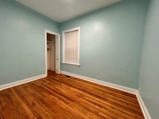 unfurnished bedroom with hardwood / wood-style flooring and a closet