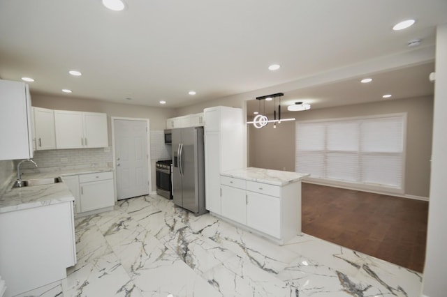 kitchen featuring white cabinetry, stainless steel appliances, decorative light fixtures, sink, and decorative backsplash