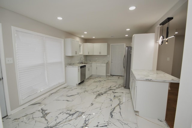 kitchen with white cabinetry, sink, stainless steel appliances, tasteful backsplash, and decorative light fixtures