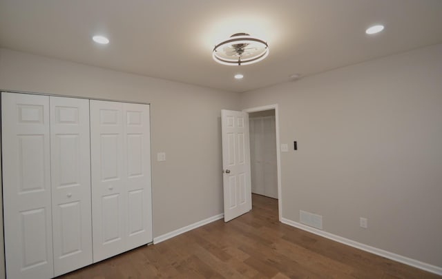 unfurnished bedroom featuring hardwood / wood-style flooring and a closet