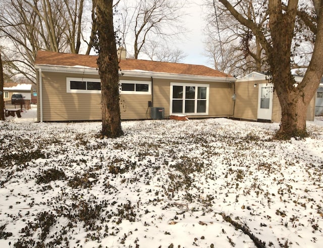 snow covered house with central AC unit