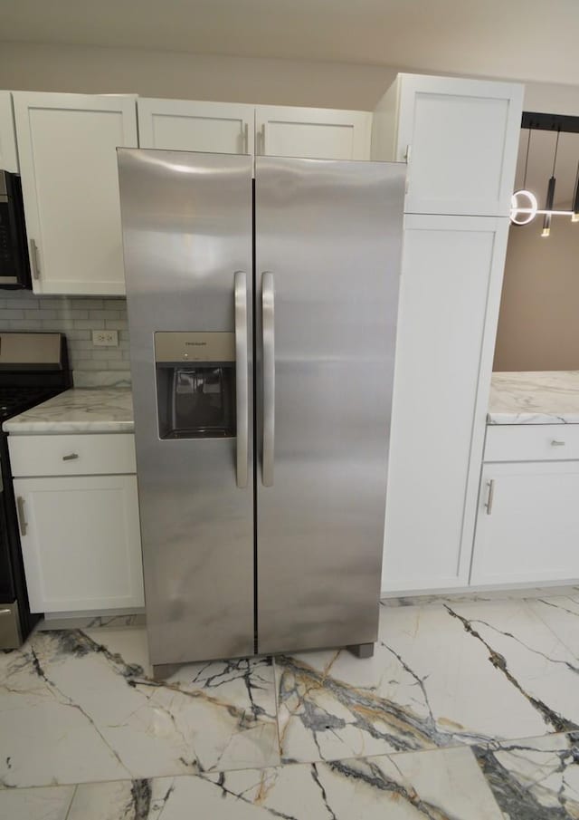 kitchen featuring tasteful backsplash, stainless steel appliances, light stone countertops, pendant lighting, and white cabinetry