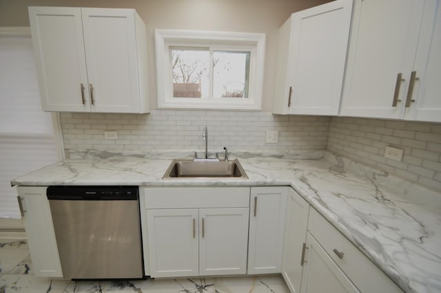 kitchen featuring stainless steel dishwasher, sink, white cabinetry, and light stone counters