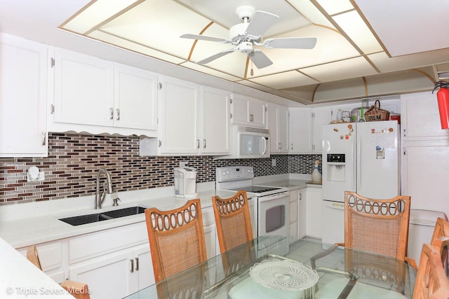 kitchen with white appliances, tasteful backsplash, white cabinetry, and sink