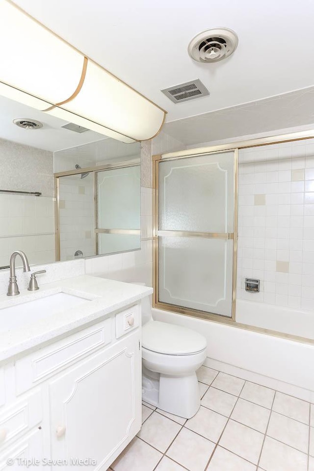 full bathroom with tile patterned flooring, toilet, vanity, and combined bath / shower with glass door