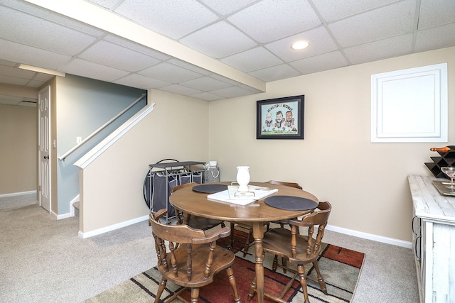 dining area with a drop ceiling and carpet flooring