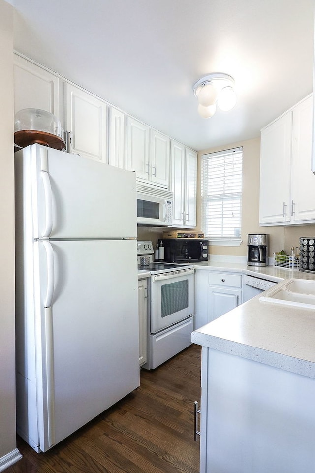 kitchen featuring white cabinets, dark hardwood / wood-style floors, sink, and white appliances