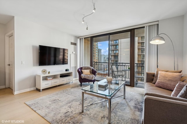 living room featuring floor to ceiling windows and light hardwood / wood-style floors