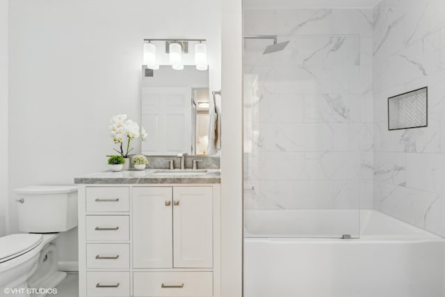 full bathroom with toilet, vanity, and tiled shower / bath