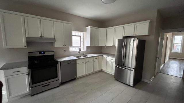 kitchen with appliances with stainless steel finishes, sink, and white cabinets