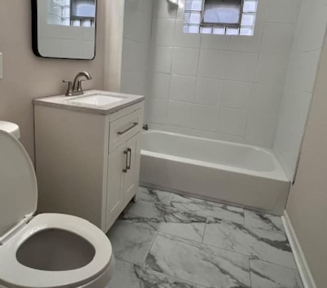 full bathroom featuring tiled shower / bath, vanity, and toilet