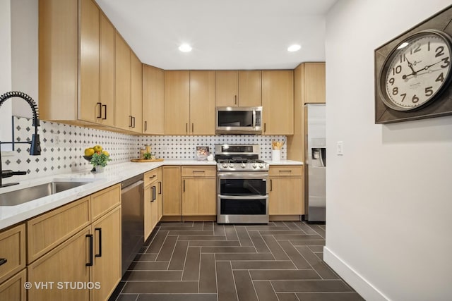 kitchen with decorative backsplash, appliances with stainless steel finishes, light brown cabinetry, and sink