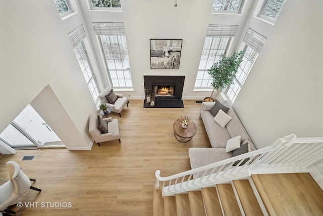 living room with hardwood / wood-style floors and a towering ceiling