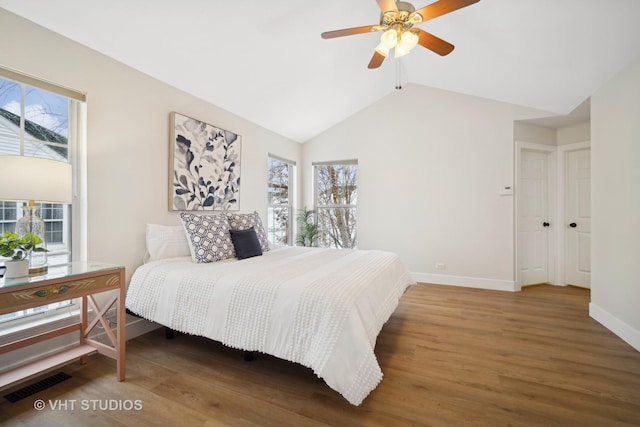 bedroom with hardwood / wood-style floors, ceiling fan, lofted ceiling, and multiple windows