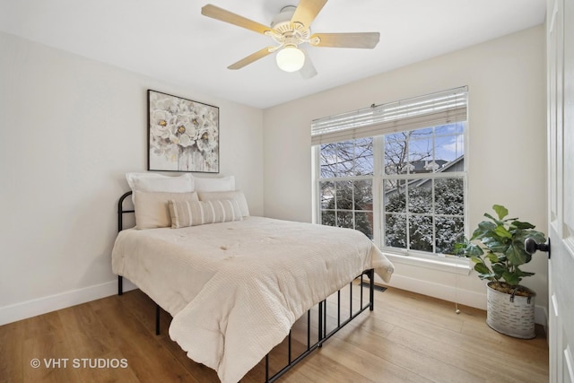 bedroom with multiple windows, ceiling fan, and light hardwood / wood-style flooring