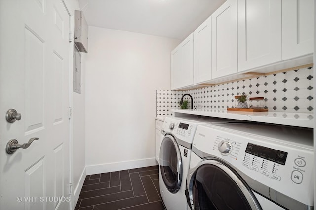 laundry area with washing machine and dryer, cabinets, and dark tile patterned flooring