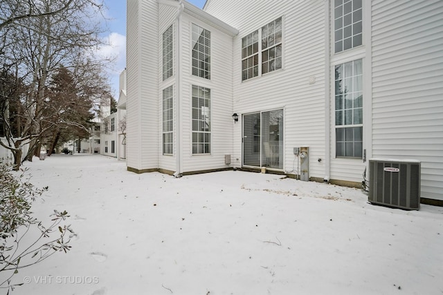 snow covered property with central AC unit