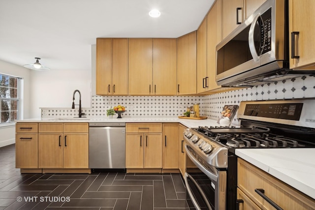 kitchen featuring light brown cabinets, sink, ceiling fan, kitchen peninsula, and stainless steel appliances