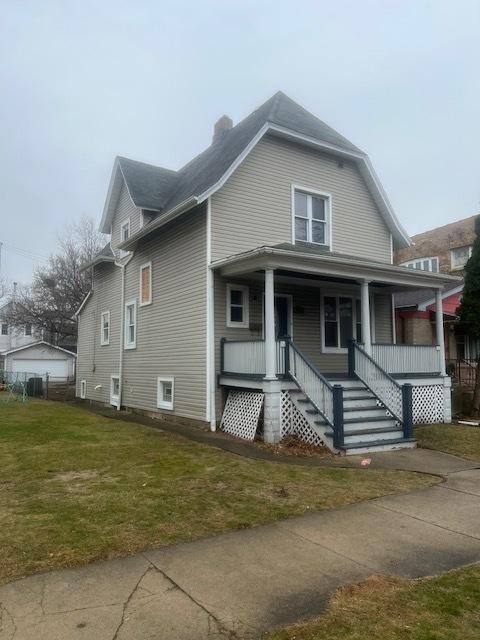 bungalow featuring covered porch and a front yard