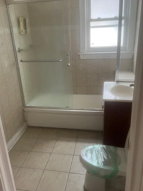 bathroom featuring tile patterned flooring, vanity, and an enclosed shower