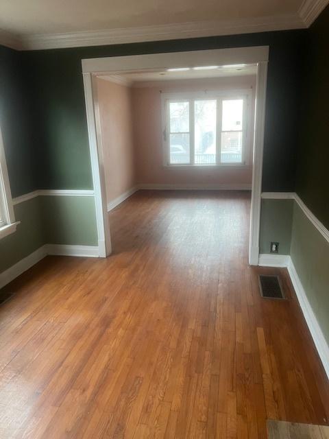 spare room featuring light hardwood / wood-style flooring and ornamental molding