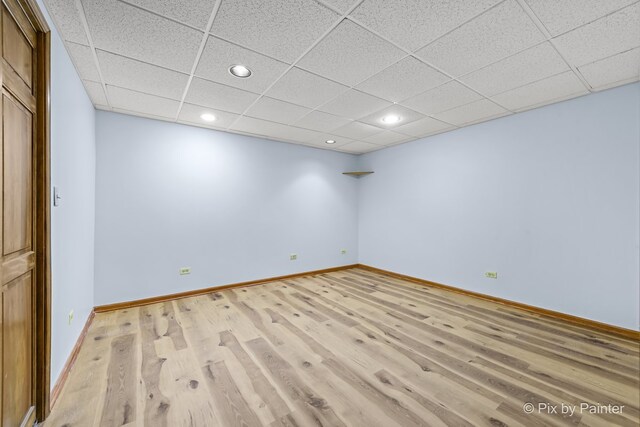 interior space with a drop ceiling and light wood-type flooring