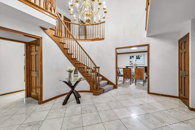 stairs featuring tile patterned flooring, a towering ceiling, and a notable chandelier