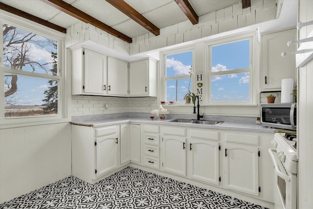 kitchen with sink, white cabinets, beamed ceiling, and white range with electric cooktop