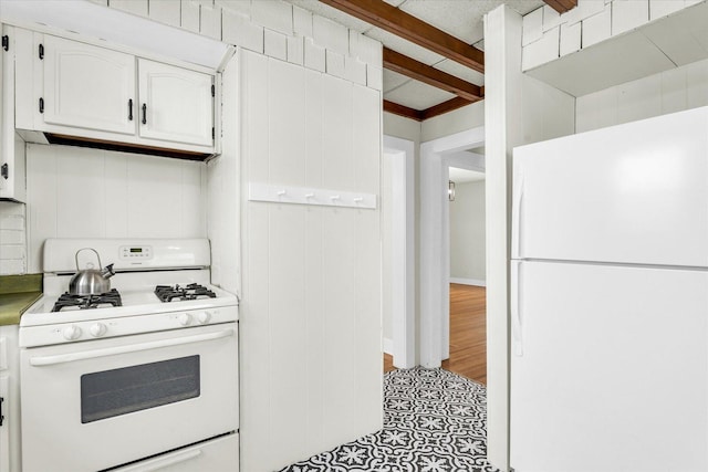 kitchen with beam ceiling, white cabinets, and white appliances