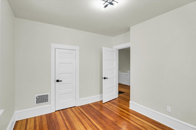 unfurnished bedroom with hardwood / wood-style floors and a closet