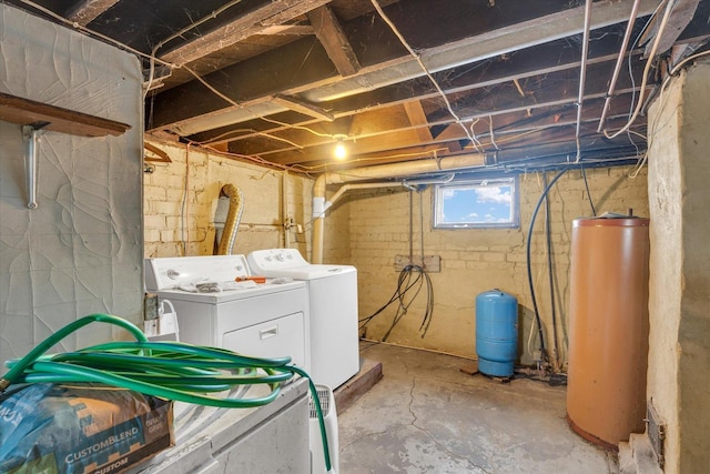 clothes washing area featuring gas water heater and independent washer and dryer