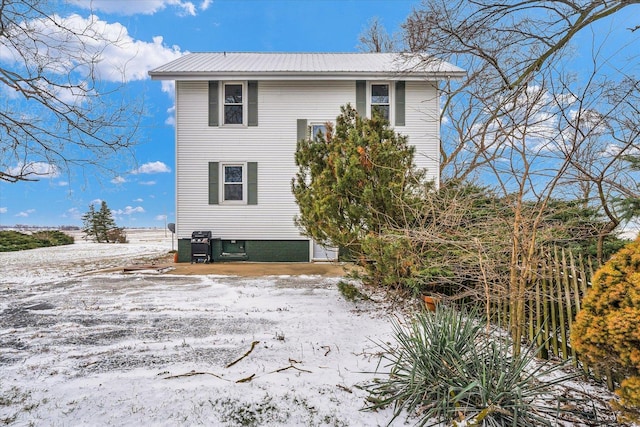 view of snow covered back of property