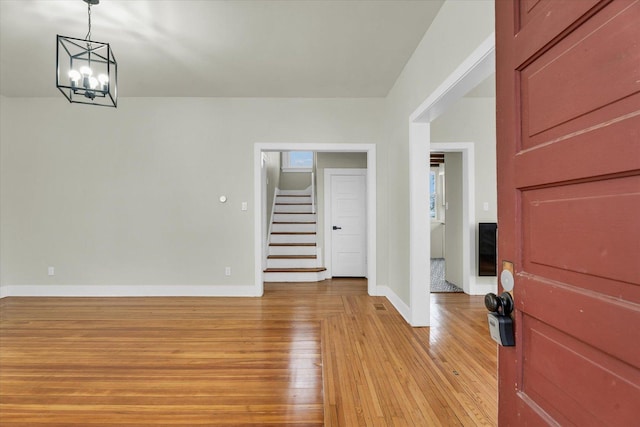 foyer featuring light wood-type flooring and an inviting chandelier