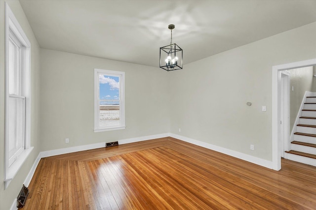 unfurnished dining area with hardwood / wood-style floors and a chandelier