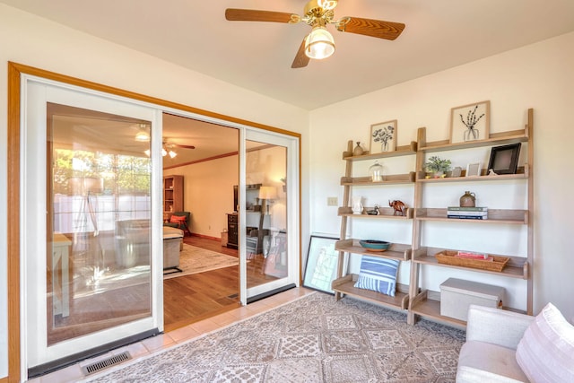 doorway with ceiling fan and light tile patterned flooring