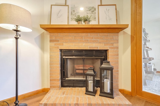 interior details with hardwood / wood-style flooring and a brick fireplace