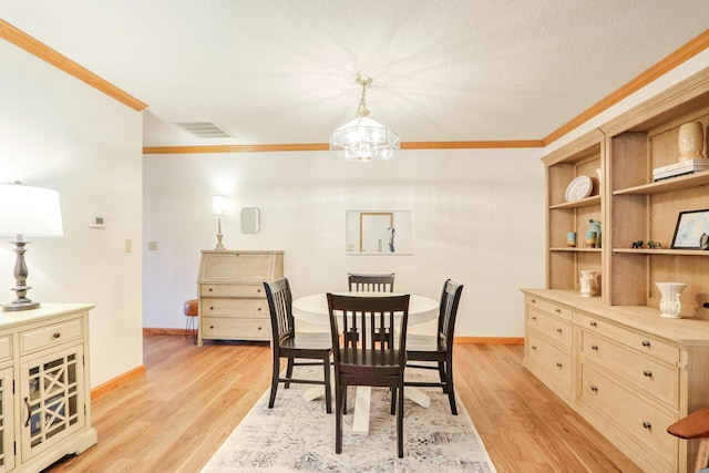 dining space featuring ornamental molding, a textured ceiling, a chandelier, and light hardwood / wood-style floors