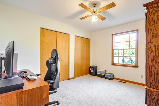 office space with ceiling fan and light carpet